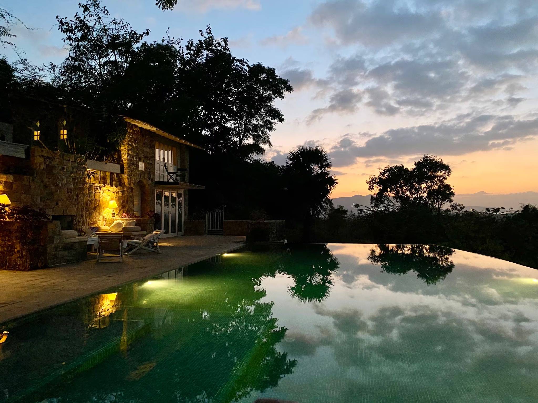 Firefly infinity pool and stone house at sunset